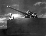 Man with microphone in gun emplacement on transport ship home from CBI to US after WWII.
