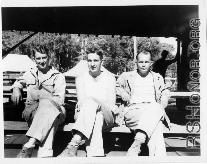 Engineers of the 797th Engineer Forestry Company pose a plank mess tables at a camp in Burma.  During WWII.