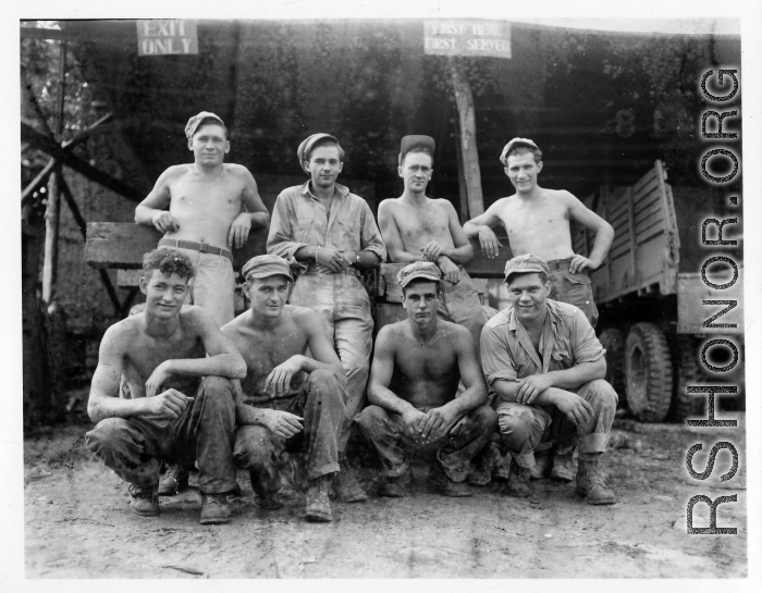 Engineers of the 797th Engineer Forestry Company pose outside truck repair garage at camp in Burma.  During WWII.