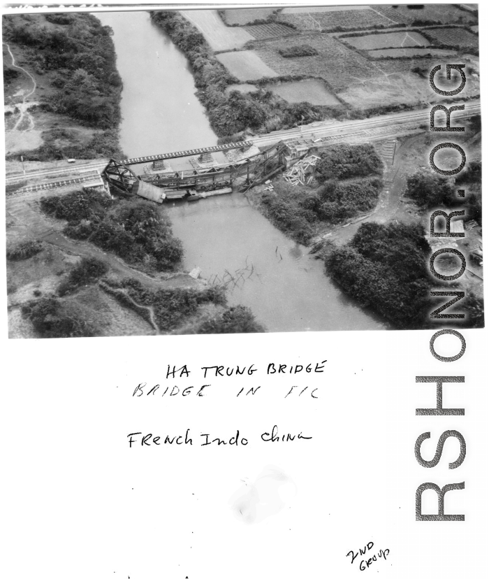 Bomb railroad bridge in French Indochina (Vietnam), during WWII. Note train engine on its side in water, and rebuilt temporary bridge nearby.  22nd Bombardment Squadron, 2nd Group.