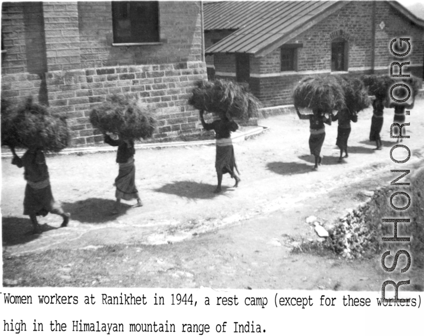 Women carrying bundle of straw or brush at the rest camp at Ranikhet in 1944, high in Himalayan mountain range of India. During WWII.