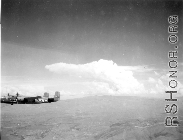 B-25 Mitchell bomber #439 in flight in the CBI, in the area of southern China, Indochina, or Burma.