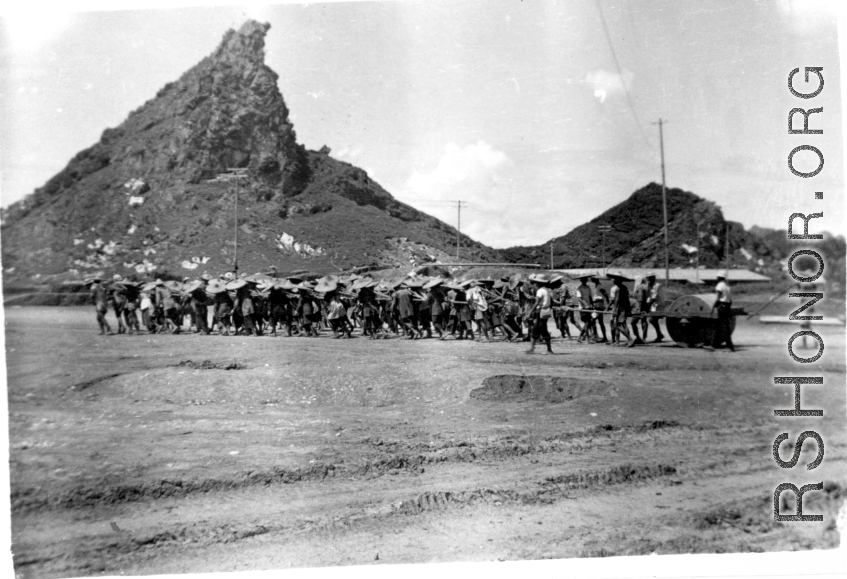 Yang Tong Airbase In 1944:"All the runways in China were made of crushed stone. They started the base with the larger stone and each layer that was added was of a smaller stone. The final layer of the runway surface was was made of finely crushed stone that was rolled and rerolled by Chinese coolies pulling a huge stone roller as shown in this picture. One of the big problems with our runways was the larger stone kept working their way to the surface and the runways had to be constantly policed to remove th