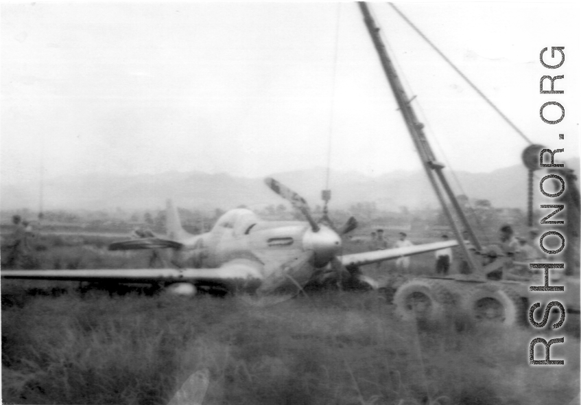 "Here is a picture of Sgt. Miller and Sgt.Blumer's salvage vehicle at work picking up a P-51 that had to make a gear-up landing."