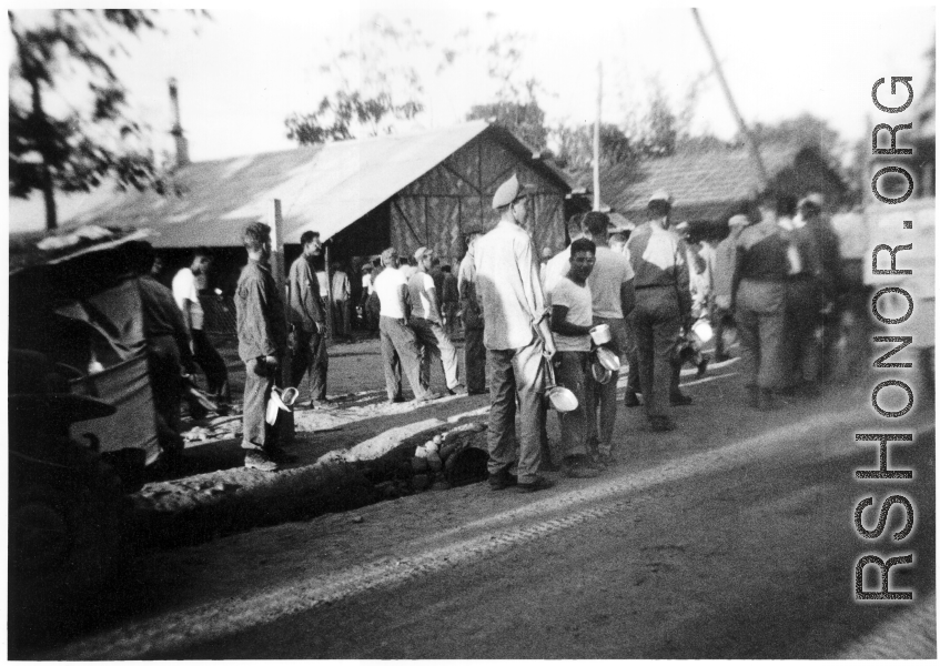 GIs of 7th Veterinary Company pose with mess gear in front of tents in the CBI during WWII.