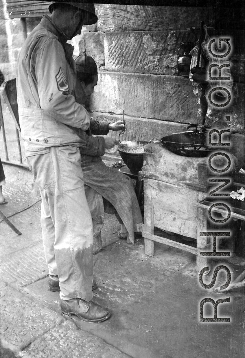 "This Chinese vendor located his 'place of business' along the road from Kunming to Chengdu. He was selling small nuts that were deep fried. An American convoy stopped in this area and an American soldier took advantage of the time to make a purchase."