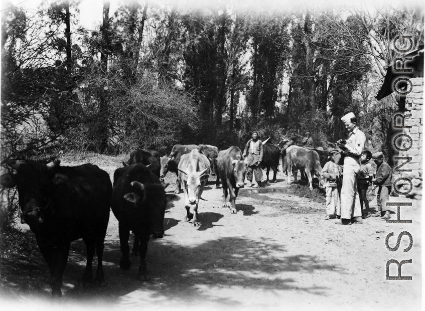 GI carrying a camera entertains interest boys at Yangkai village. During WWII.