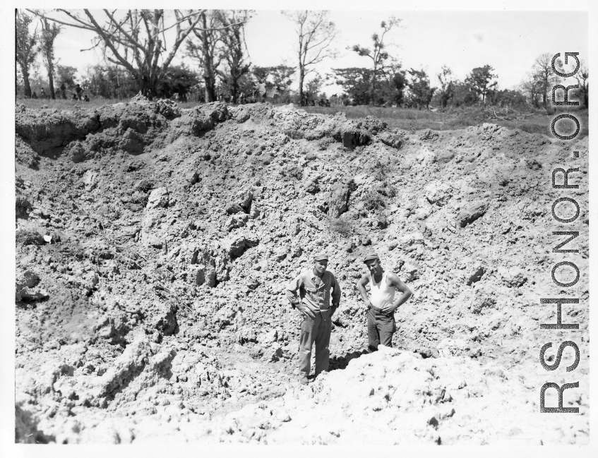 GIs examine giant bomb crater in Burma.  During WWII.  797th Engineer Forestry Company.