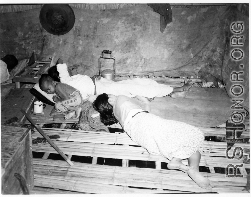 People sleeping inside home in Burma.  In Burma near the 797th Engineer Forestry Company.  During WWII.