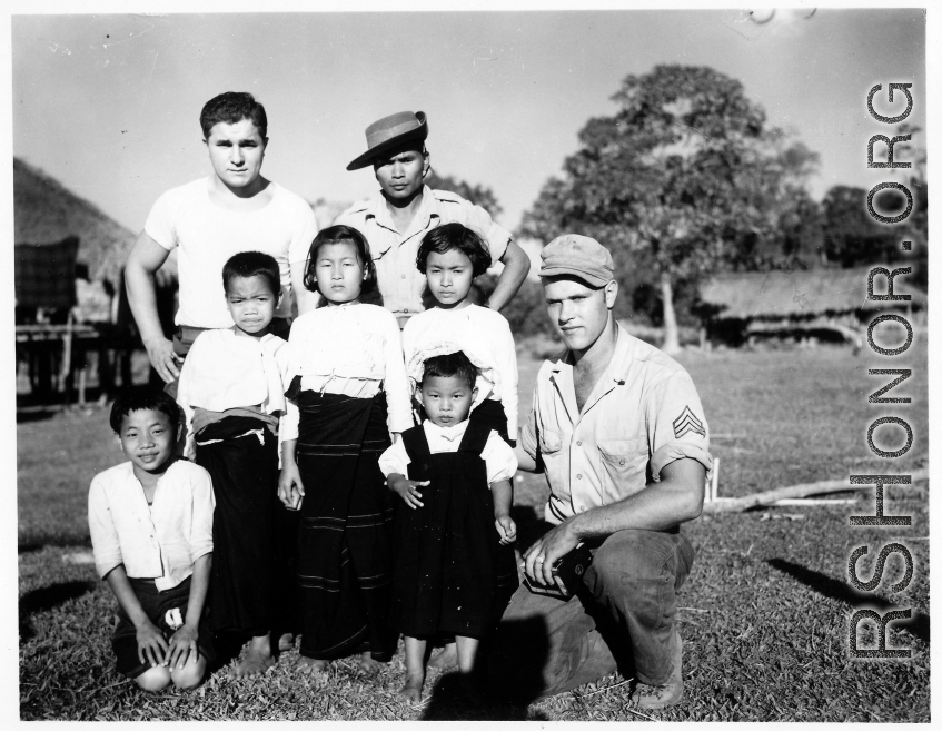 Local people in Burma near the 797th Engineer Forestry Company--GIs pose with man and children in Burma.  During WWII.