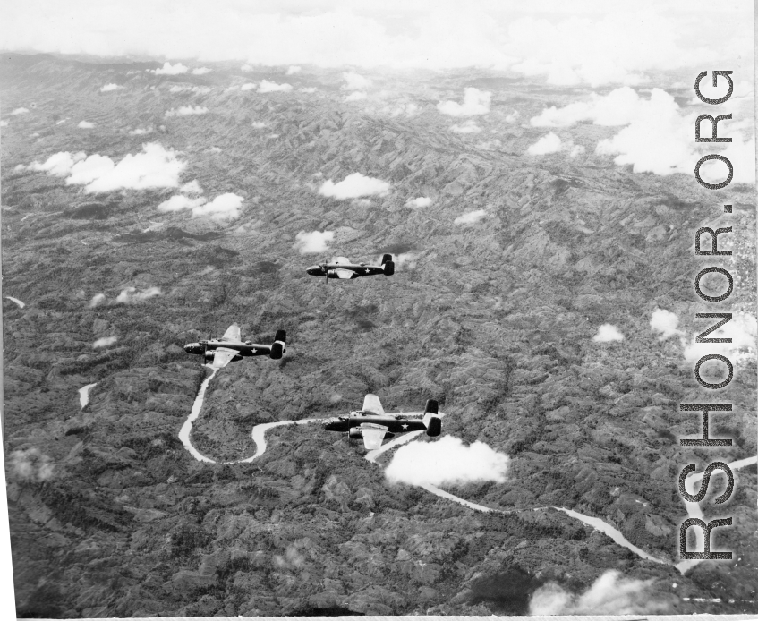 B-25s of the 22nd Bombardment Squadron in flight over thick forests in SW China or Burma during WWII.