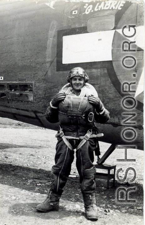 American flyer Gérard Labrie with B-24 bomber "80 Days" during WWII. Note his heavy clothing and parachute.