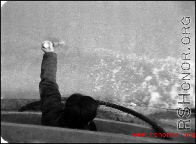 Man uses pole to check water depth in northern China during WWII, probably on the Yellow River.