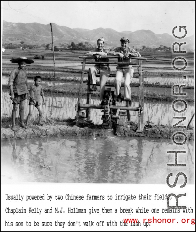 Chaplain Kelly and M. J. Hollman try out foot-powered water pump in a rice paddy in SW China during WWII, as members of farm family look on.