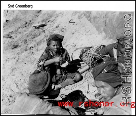 Workers take a break to eat, possibly resting from road building in SW China or Burma. During WWII.