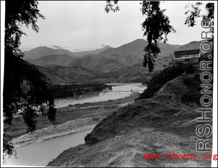 A river valley in SW China, either Yunnan or Sichuan, during WWII, with a pedestrian rope bridge across the river. Photo from Dorothy Yuen Leuba.