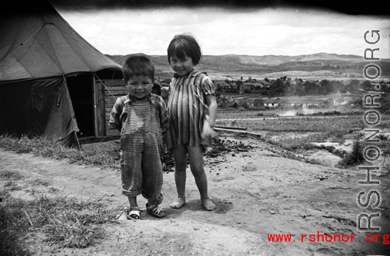 A boy and girl playing in Yunnan, China, near an American air base. During WWII.