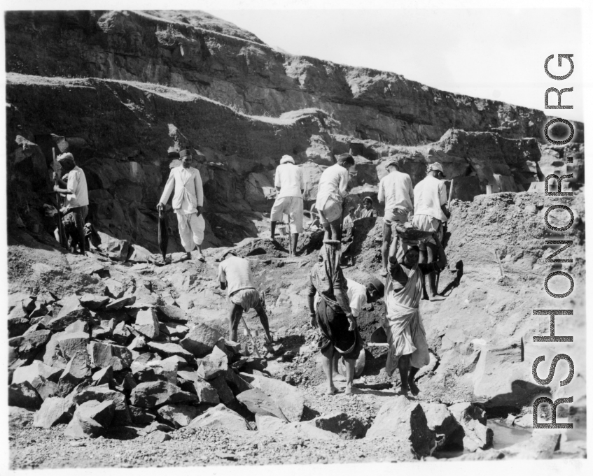 Men quarry rocks by hand.  Scenes in India witnessed by American GIs during WWII. For many Americans of that era, with their limited experience traveling, the everyday sights and sounds overseas were new, intriguing, and photo worthy.