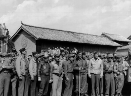 10CU 567 36 BURMA ROAD (RES). Soldiers at ease in China, waiting for arrival of a convoy over the Burma Road or listening to a commemorative speech about the opening of the road. A movie camera is set to go on the truck to the right.