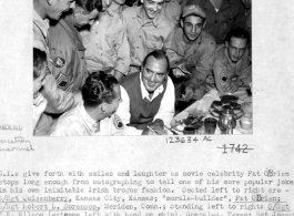 GIs in China enjoy time laughing at movie celebrity Pat O'Brien's jokes.  Seated left to right are S/Sgt. Quisenberry, Pat O'Brien, S/Sgt. Robert L. Sorenson. Standing are S/Sgt. T. W. Wilson, Sgt. Joseph Campion, S/Sgt. Leslie Piehl, S/Sgt. Jerry Dusek, Sgt Wallace Jackson, Sgt. Henry E. Kubieck, Pvt. Gordon Escore. In rear are Pvt. Kenneth Hummel, Sgt. Andrew Adamchik, S/Sgt. Charles J. Kekura, Pvt. Frank Puccio, and Sgt. Stanley Breckner.