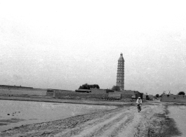 A man bicycles on dusty road near the Chengtian Temple Pagoda in Yinchuan, in northern China, during WWII.   二战期间银川的承天寺塔。