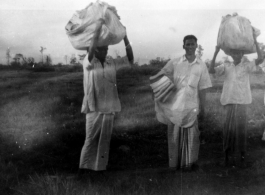 Men carrying laundry in India during WWII.  Local images provided to Ex-CBI Roundup by "P. Noel" showing local people and scenes around Misamari, India.  