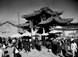 Local people in Yunnan province, China: A busy gate and market area. During WWII.