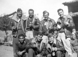 GIs pose with bottles of beer in China during WWII: "This Is A Bunch Of 396th Party Boys Enjoying A Little Brew At Luliang,China. Kneeling: Chinese man, Winter, and Walker. Standing: Gerdsen, Garver, Rush, and Tacey."