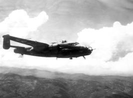 B-25 Mitchell bomber #448 in flight in the CBI, in the area of southern China, Indochina, or Burma.