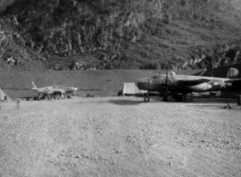 "The Latest In Shops And Equipment--This a picture looking into a revetment that served as our work area and engineering area at Luichow [Liuzhou], China. Lt. Sohl's office was in the little shack at the right and all our tools and equipment was in the tent. We changed a lot of B-24 engines in this revetment along with replacing blown out tires and doing sheet metal repair work. We worked here until the Japanese forced us to evacuate the base and return to Luliang." Caption courtesy of Elmer Bukey.