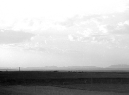 A view across a valley with grave mounds visible. Probably in China, in Kunming province. During WWII.