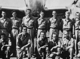 Men from the 21st Photographic Reconnaissance Squadron pose for a group shot in front of an F-5 (a variant of the P-38).