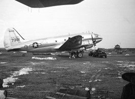 The C-46 transport tail #347391 parked at the American base at Luliang, China. The control tower can be seen in the background. During WWII.