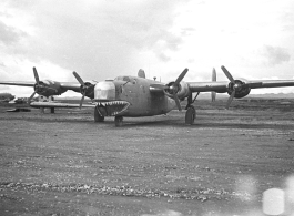 The Consolidated B-24 bomber "Nip Nipper," serial #42-72837. This is later in the war, and the B-24 has been modified to carry cargo, with the nose guns (and much more) removed. Note the aircraft wing on blocks to the left, and the salvaged C-47 fuselage in the background. During WWII, in China.