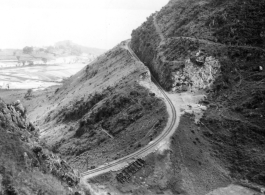 A train track--with a flipped flatcar--in Yunnan province, China. Near Camp Schiel. Yangzonghai Lake is in the background.  During WWII.