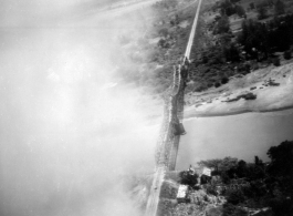 B-25 Mitchell bombers have just bombed a railroad bridge a bridge somewhere in southwest China, Indochina, or Burma, leading to no apparent damage, but a large cloud of dust and smoke. 