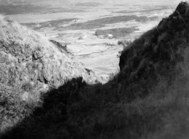 An American serviceman (partially hidden in shadow) walking on the hill above Yangkai air base, in Yunnan province, China, during WWII. He is being escorted by a local boy.