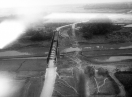 Aerial view of auto bridge and fields in either SW China or French Indochina, in the CBI, during WWII.