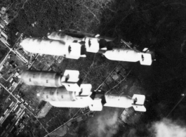 Bombs fall over tidy buildings in Burma or French Indochina, in the CBI, during WWII.