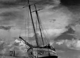 Boat 'Icaros" ground on the sandy shore in India.  Scenes in India witnessed by American GIs during WWII. For many Americans of that era, with their limited experience traveling, the everyday sights and sounds overseas were new, intriguing, and photo worthy.