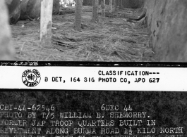 Former Japanese troop quarters built in revetment along Burma Road 1.5 kilo north of Zhefang. This place differs from others shown in that roof is made of heavy sheet steel and added protection is afforded by row of earth filled gasoline drums set around the top of earth bank forming wall closest to Burma Road.  December 6, 1944.  Photo by T/5 William E. Shemorry. 164th Signal Photographic Company, APO 627.  Passed by William E. Whitten.