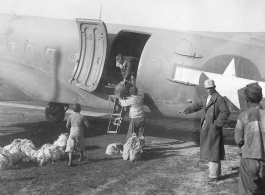 From a C-47 these Chinese are seen unloading food for the Chinese who are building the new road towards the  Burma border to meet the Ledo Road.  December 11, 1944.  Photo by T/Sgt. S. L. Greenberg. 164th Signal Photographic Company, APO 627.  Passed by William E. Whitten.