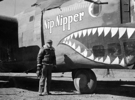 Selig Seidler, camera in hand, standing before the B-24 "Nip Nipper" somewhere in China during WWII.