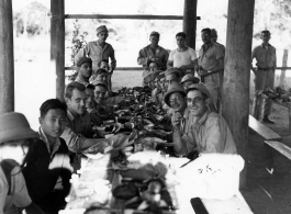 Engineers of the 797th Engineer Forestry Company eating fancy meal in Burma, possibly in the stilt space under a private home.  During WWII.