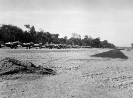 A row of tightly packed American aircraft at at an airstrip in Burma, probably in 1944, including B-25, P-40, C-47, P-47, etc. Apparently they were not concerned about Japanese air raids given the tight layout.  Aircraft in Burma near the 797th Engineer Forestry Company.  During WWII.