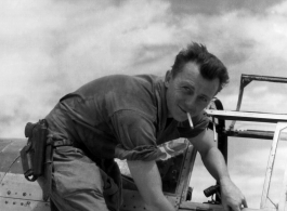 Henry E. Miehe, pointing to battle damage on his airplane. China, WWII.