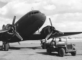 GIs in jeep wait before C-47 transport in China, during WWII. The jeep has a white placard saying "Airdrome Officer."   Although ICD-ATC is stenciled on the jeep, indicating Dum Dum Air Base, the terrain in the background is definitely not that of Dum Dum, and should be China. 