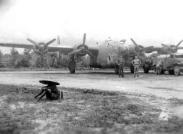 American flyers pose before B-24 "Doodlebug" In SW China as the bomber is being refueled.  During WWII.