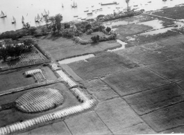 Aerial view showing boats, river, farm plots during mission to bomb Tourane, Indochina, by 22nd Bombardment Squadron in the CBI.  "Our longest mission. The river port of Tourane, French Indochina."