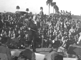 Conductor Andre Kostelanetz directs at a USO show in Gushkara, India, during WWII.  The boxes in front of the band players are labeled 748th ROB (748th Railway Operating Battalion).